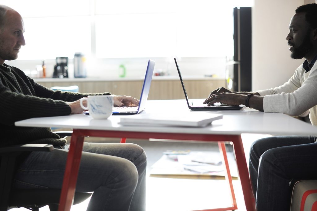 two people meeting with computers